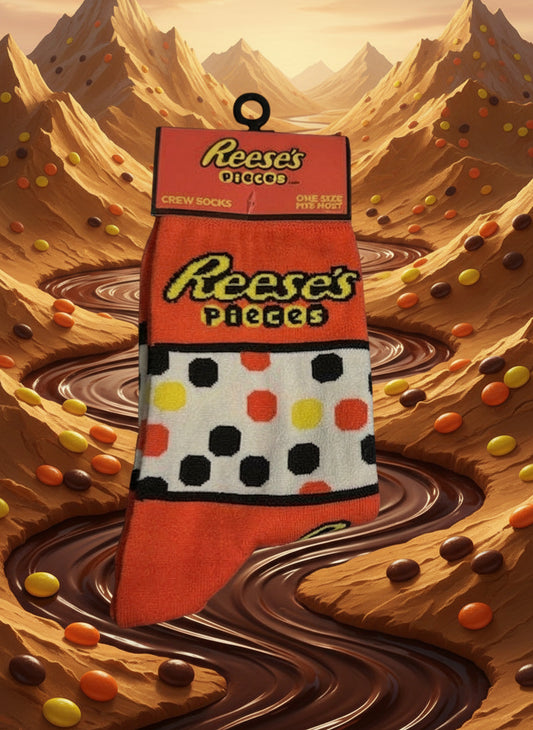 Reese's Pieces themed sock with packaging on a peanut butter and chocolate background