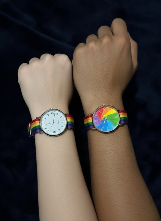 Two watches with rainbow straps on a dark background